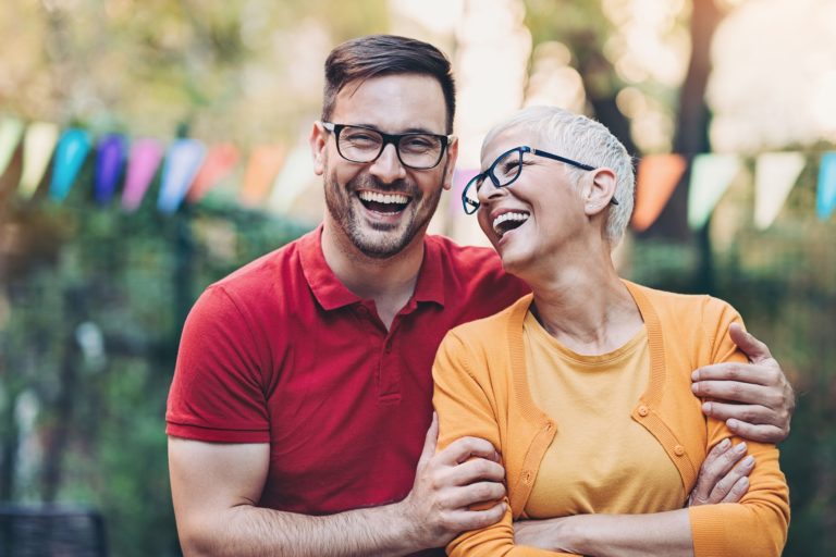 A man and woman in an outdoor setting laughing together