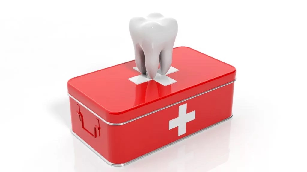 Illustration of a white tooth on top of a red first aid kit