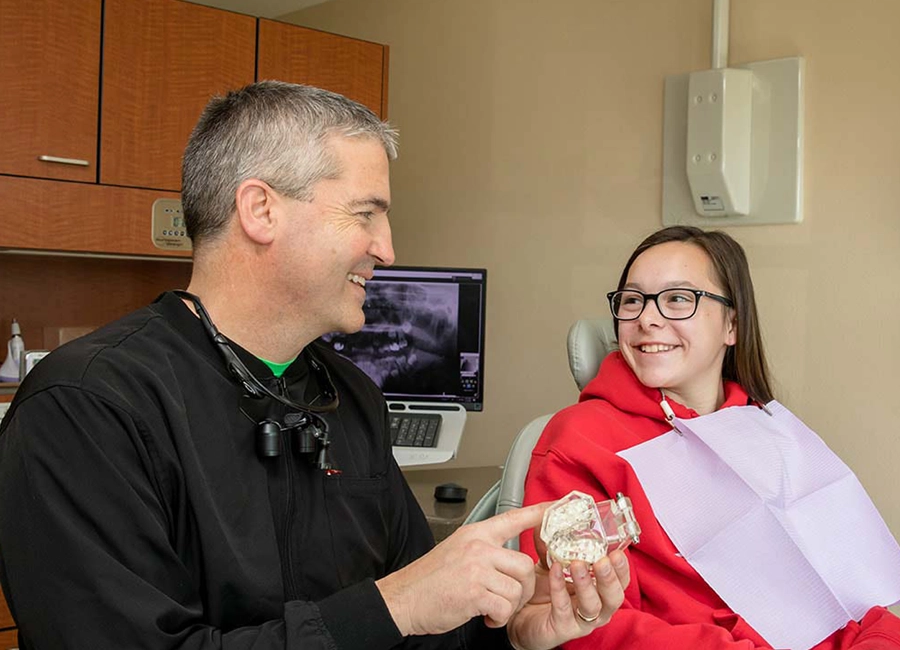 Dr. Craig Burhoop talking to a young dental patient about the No Cavity Club at The Dentist of Siouxland.